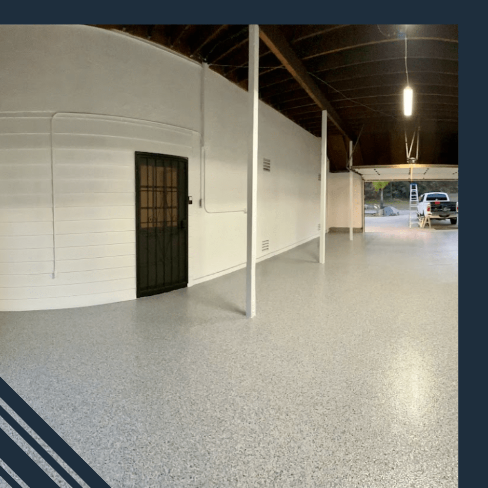 Epoxy-coated garage floor showcasing a clean, modern space with white walls, a black door, and a vehicle in the background, illustrating Pristine Epoxy Floor Coatings' transformative flooring solutions for residential and commercial settings.