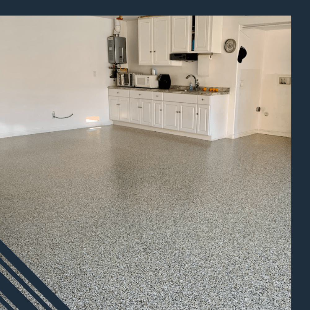 Epoxy-coated garage floor showcasing a clean, modern aesthetic with white cabinetry and appliances in a well-lit space, highlighting Pristine Epoxy Floor Coatings' transformative flooring solutions.