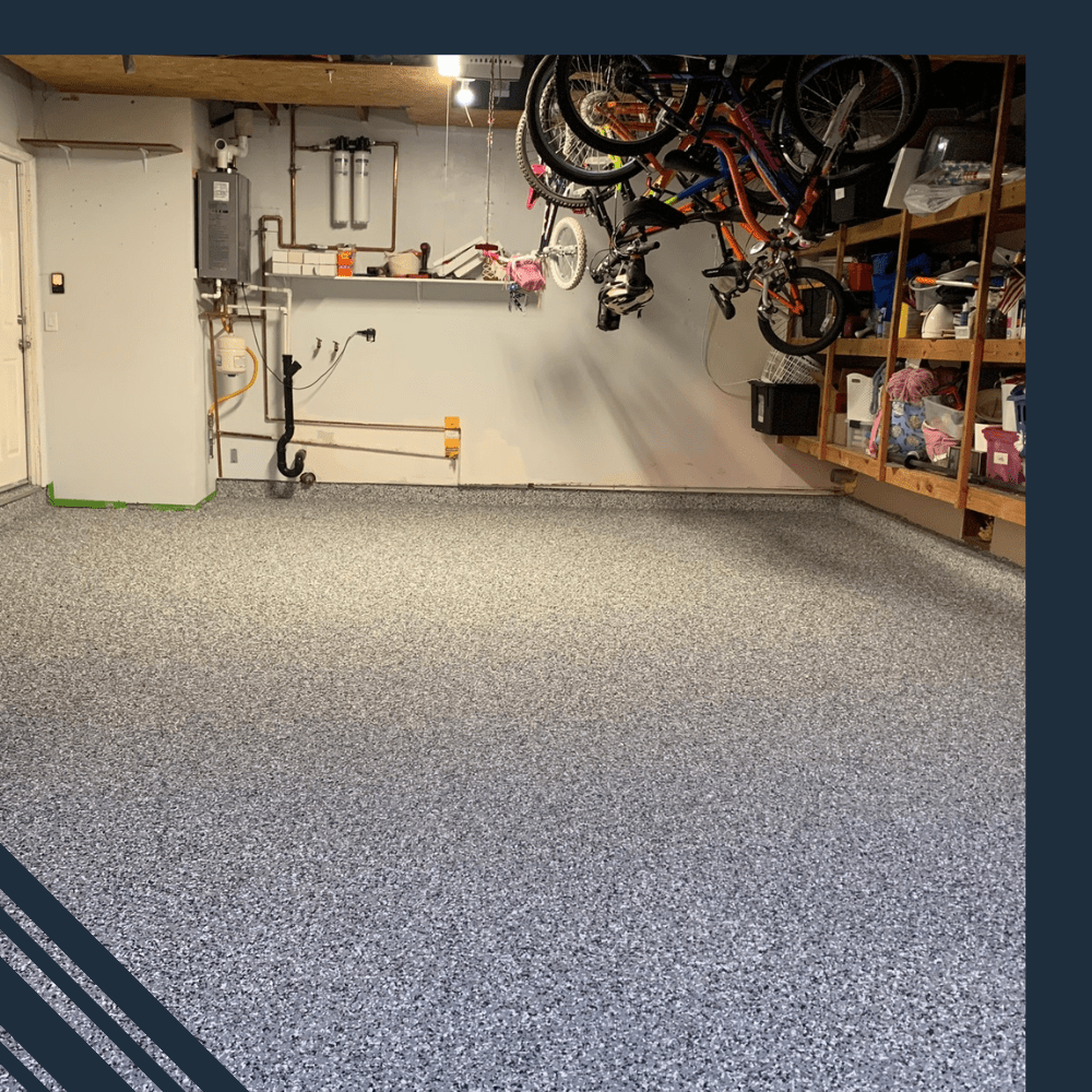 Garage with newly installed epoxy flooring showcasing a speckled gray finish, bicycles hanging from the ceiling, and organized storage shelves, illustrating Pristine Epoxy Floor Coatings' transformation capabilities.