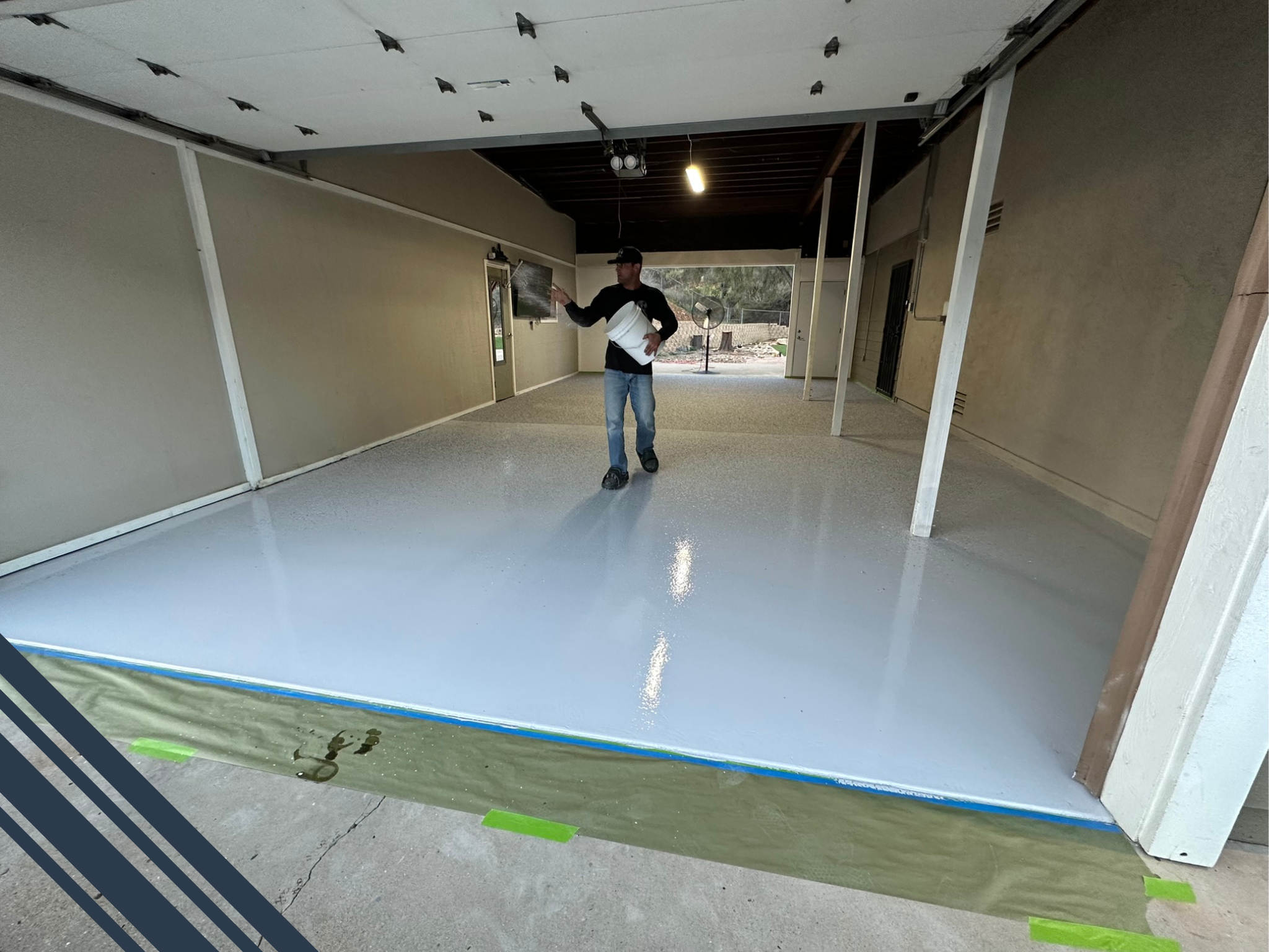 Person applying epoxy flooring in a garage space, showcasing a clean, glossy surface that enhances property value in San Diego.