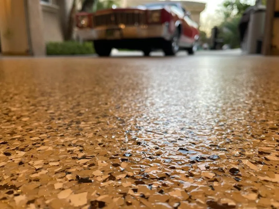 Shiny garage floor with a red vintage car in the background.