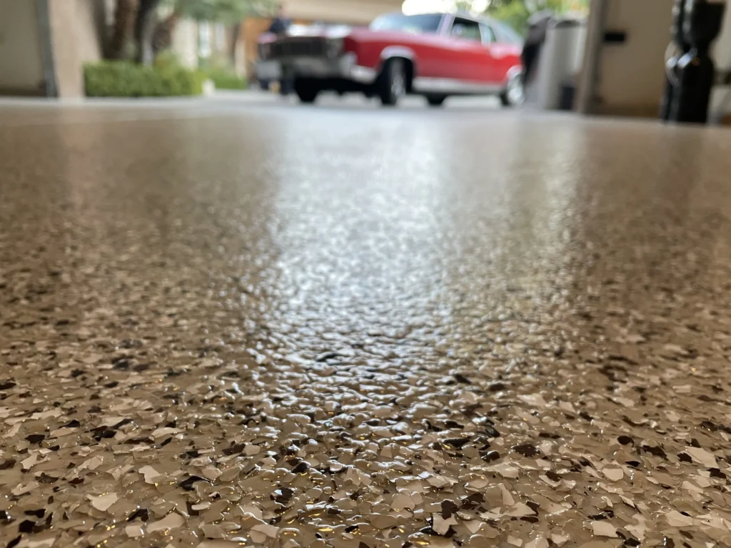Homeowner cleaning epoxy garage flooring with a mop, illustrating easy maintenance